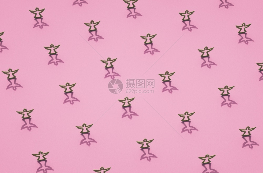 角度粉红表面圣诞装饰品上天使的灰色垫子轮廓有阴影的圣诞主题背景马特玩具图片