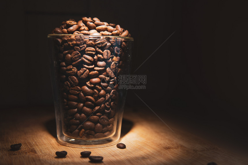 装满咖啡豆的玻璃杯图片