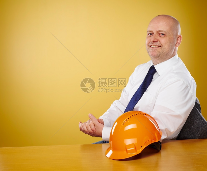 放松办公室的男工程师他穿着白衬衫和领带橙色硬帽在桌子上轻松工作台图片