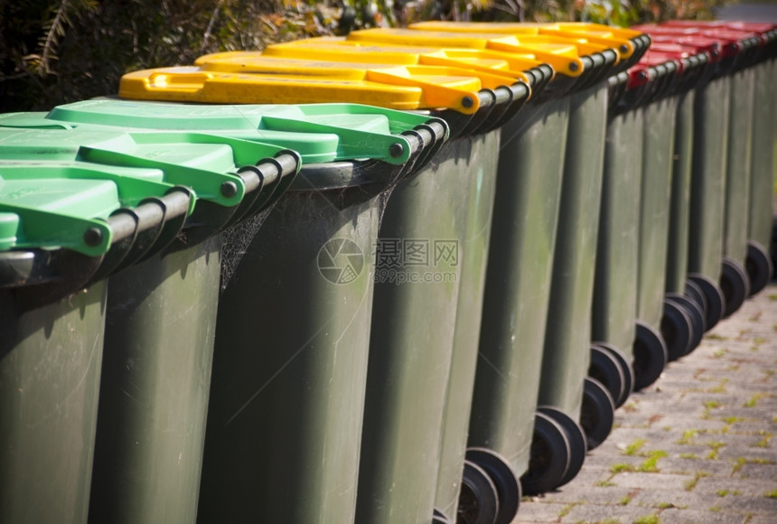 用于垃圾的大型绿色轮式垃圾桶行外部明亮的图片