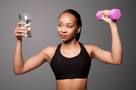 美丽健康的黑人亚洲女有杯水和哑铃重力锻炼身体护理吸引人的亚洲图片