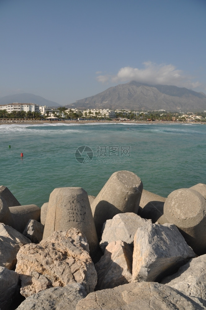 山西班牙马尔贝拉石码头PuertoBanus海滩多岩石的洋图片
