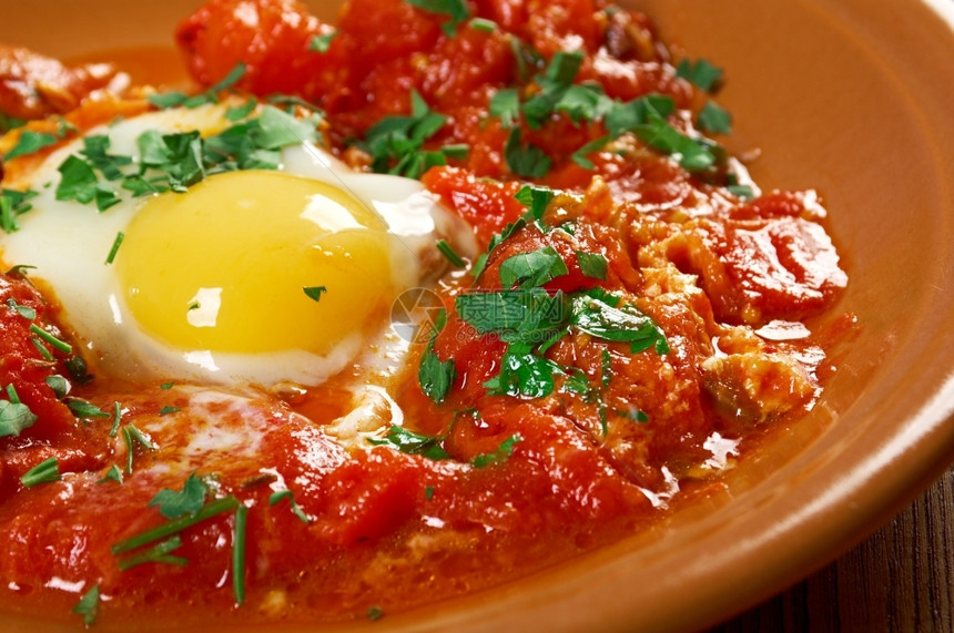 传统上番茄Shakshuka在西红柿酱辣椒和洋葱中偷吃鸡蛋通常以烹饪莫罗干菜突尼斯利比亚阿尔及和埃的烹饪为香料美食图片
