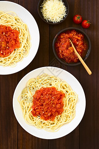 营养垂直的美食传统意大利面粉加蛋红酱在碗里加番茄酱用自然光照黑木头图片