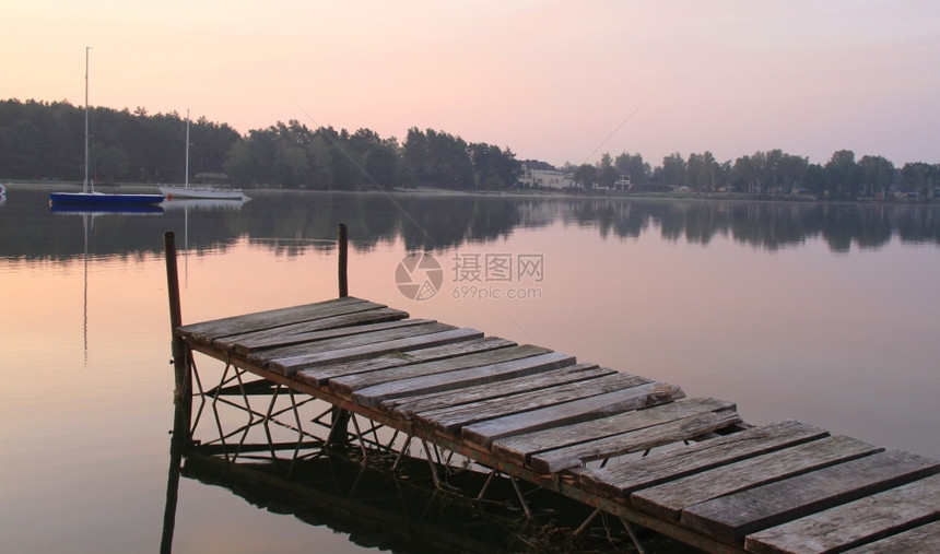 反思景观日出时湖边的Wooden码头黄昏图片
