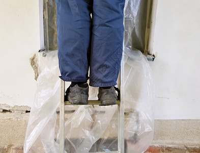 在房屋重建期间将工人的梯上腿紧建造鞋照片图片