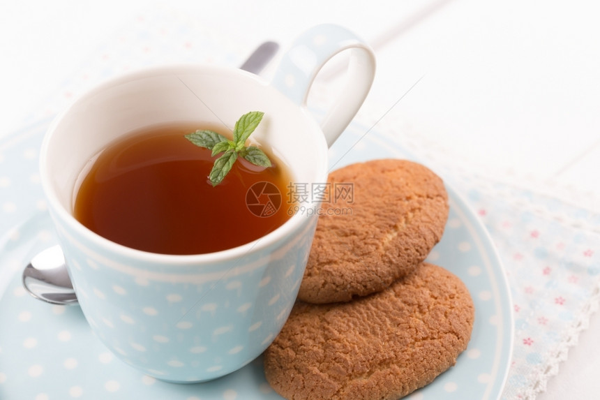 桌子有薄荷饼干的茶放在瓷杯和碟子里饮料茶点图片