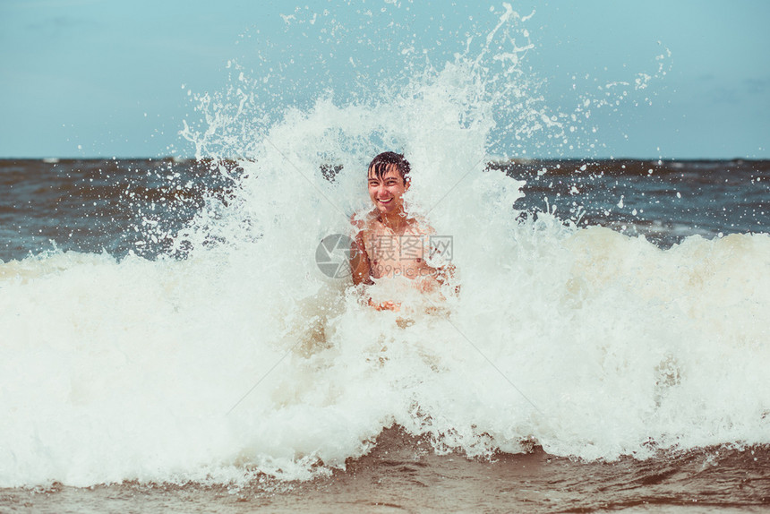 请享用年轻人在暑假期间享受海浪的盛大风在海上渡暑假时过闲暇经图片