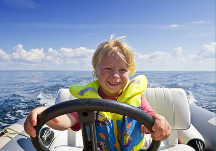 生活手舵年轻男孩驾驶着一艘充气快艇的方向盘图片