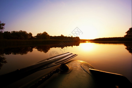 日落天空下湖上挂着划桨的船水平景观宁静背景图片
