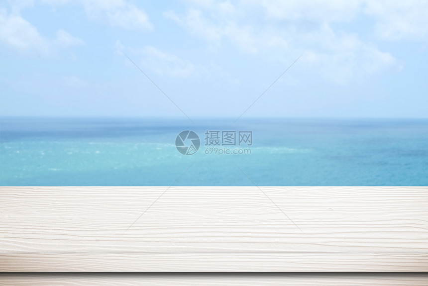 假期自然模糊海面和蓝天空背景模板产品显示时的空白木桌超过图片