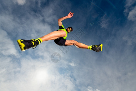 岩石男子运动员在山上奔跑的足迹中跳跃时积极的竞技图片