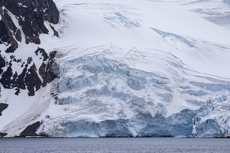 雪带白冰的南极川坠落到平静的蓝海中冷若冰霜落下背景
