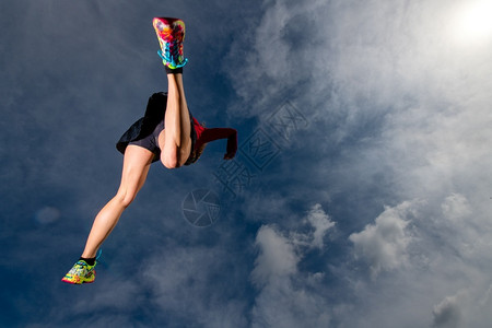户外运动员身体在山上奔跑时运动健体的女孩跳起来图片