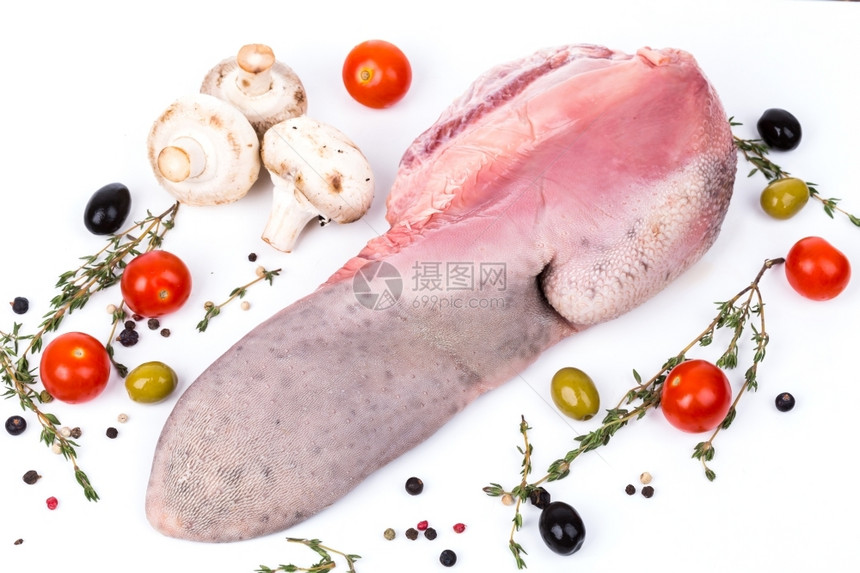 屠宰场血腥肉未煮过的生舌头在白色背景上供应香料图片