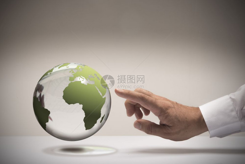 全球的人手和指着玻璃球选择旅行目的地概念图像选择您的旅行目地一种指点图片