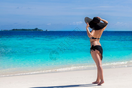 美丽的女人在沙滩海边观望夏图片