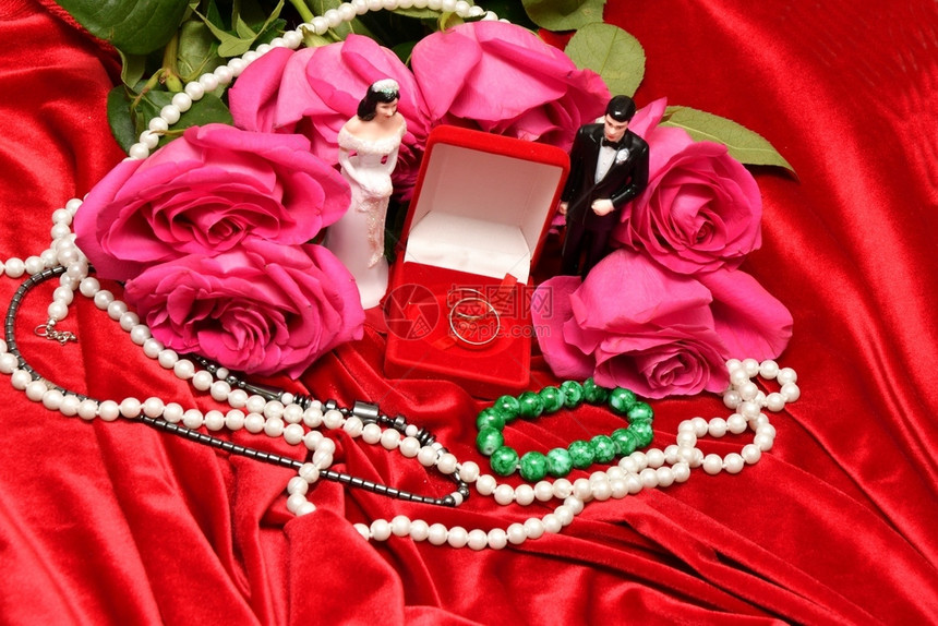 红色的粉结婚戒指和一束粉红玫瑰花假期图片