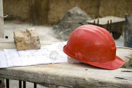细节帽子建筑学工地肮脏的红色硬帽砖头和木板上的项目图片
