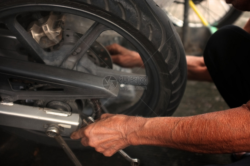 维护贴近点人们正在修理一辆摩托车使固定工具图片