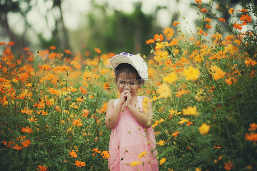 绽放在黄色宇宙中哭泣的小女孩花朵开阔的田地植物情感图片