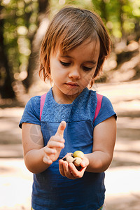金发小女孩手上拿着橡子的小桃用背包在森林的路上冒险外部青年图片