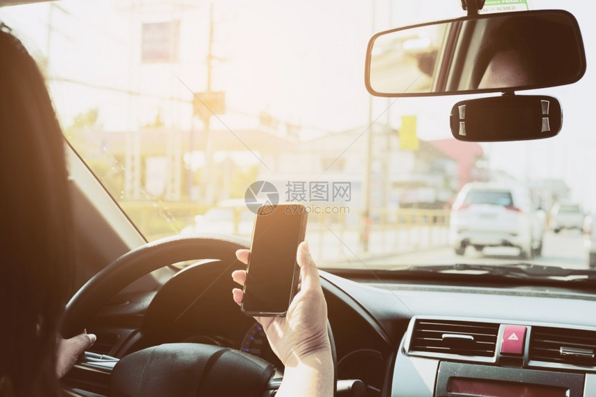 司机近距离接一个男子使用移动电话危险驾驶汽车的人和安全帽图片