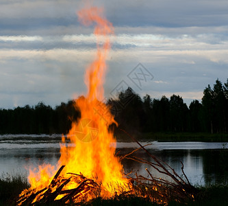 水火碰撞木板抽烟支撑芬兰夏日初湖岸大火背景