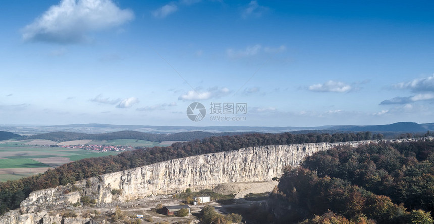 岩石钙以山为背景蓝天空和云彩为的一个村庄采石场空中景象碳酸盐图片