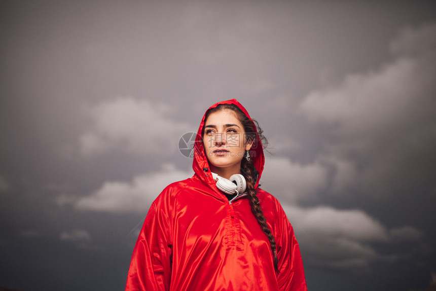 女孩年轻子在雨天与衣和耳机一起站在田地上户外秋天图片