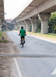 独自的上市街道现代自行车在城市公园附近路过的地方缓慢骑着现代自行车图片