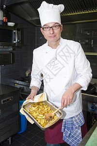 苦力白色的杓一位骄傲厨师展示了一盘炸土豆图片