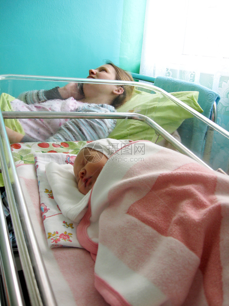在妇产医院带新生儿的妇女妈和在产医院的新生婴儿躺在小床上妈得到祝贺出生门户14健康图片