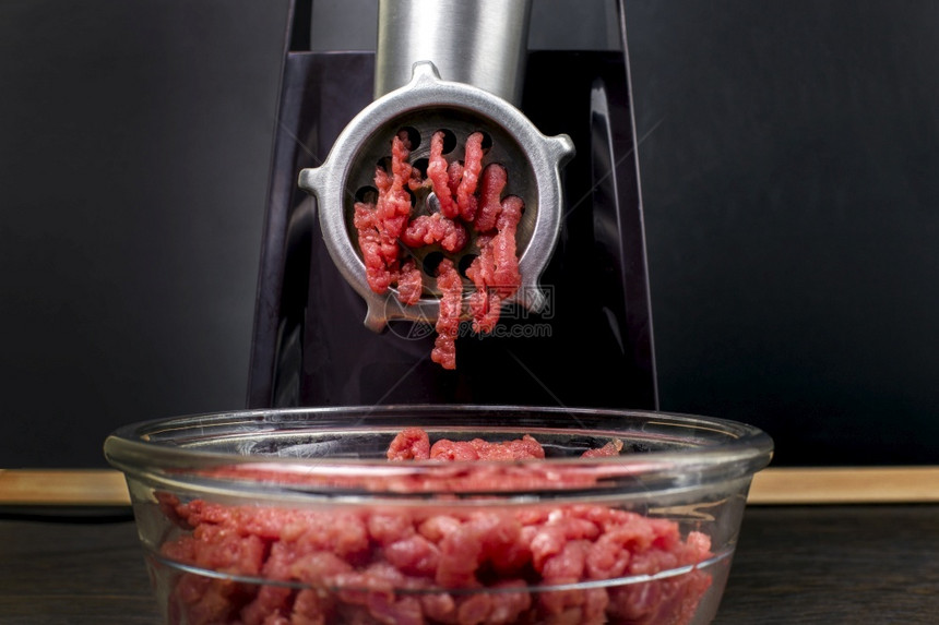 电动肉研磨机和板底上带有肉的盘子磨床食物一顿饭图片