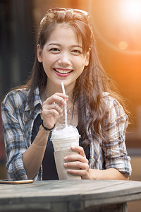 笑着微的年轻亚洲女快乐地喝冷饮料亚洲人时尚女士图片