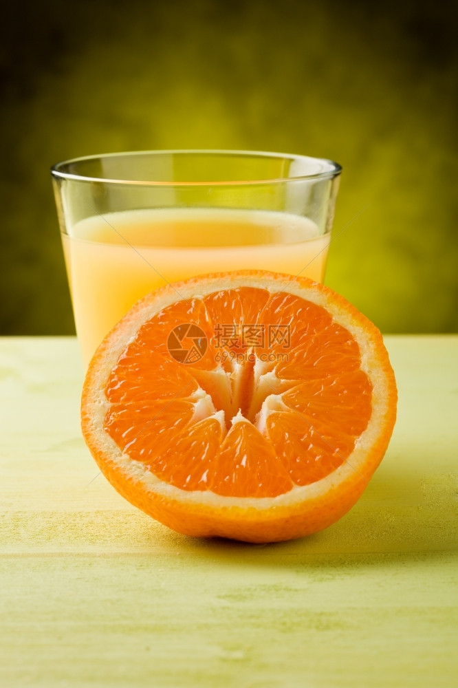 斑点喝木制桌上的玻璃杯里新鲜橙子汁果图片