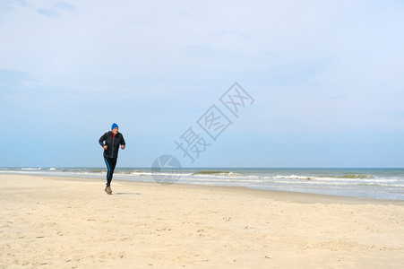 锻炼健康老人在海滩上奔跑们积极的图片