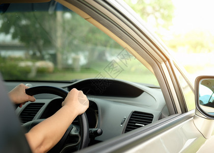 现代的手握着方向盘在光天化日下驾车里程表黑色的图片