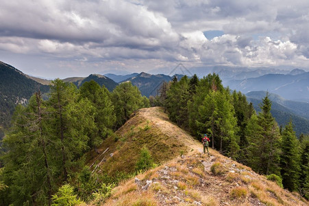 户外山脊上爬者在暴风雨的天空下行走徒步旅者景观图片