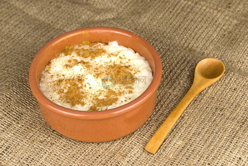 大米自制牛奶和肉桂在一个瓷碗中的陶在海珊布料之上奶油的织物香料图片