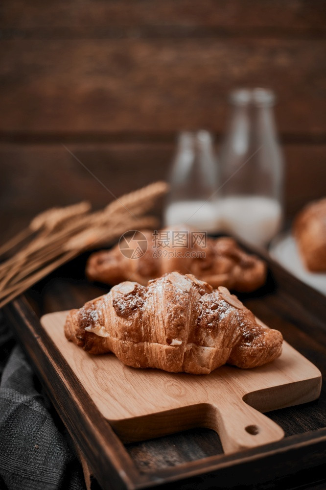 可口含奶油的杏仁角面包木本底填充早餐美食图片