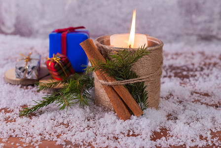 桌子一种卡片蜡烛和包装礼物放在带雪的木背景上图片