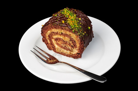 蛋糕华丽的一块巧克力和坚果卷在盘子上孤立黑色巧克力和坚果卷上烘烤的图片