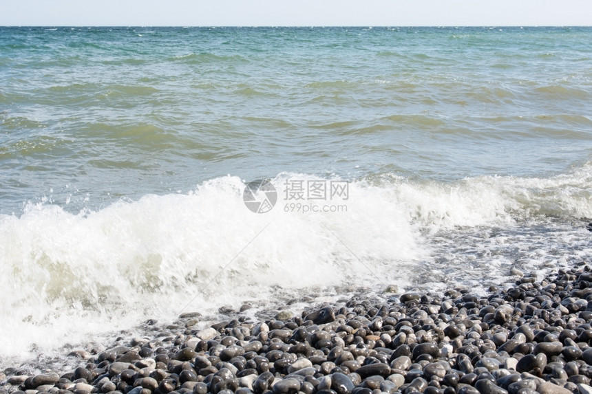 在海边有石块的面上挥舞波浪在海边有石块的戏剧岸水图片