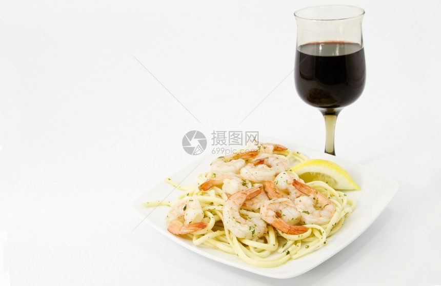 虾皮带药草和柠檬片的虾在橄榄碗面上加健康的红酒饮食午餐图片