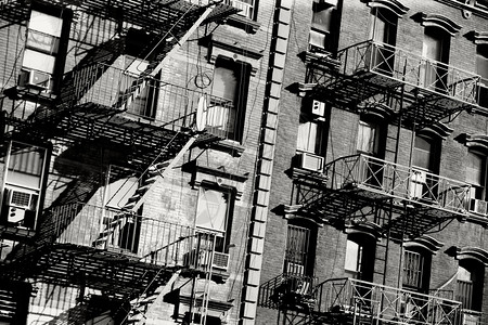 老的城市纽约一栋大楼外侧有旧防火梯的黑色和白照片梯子图片