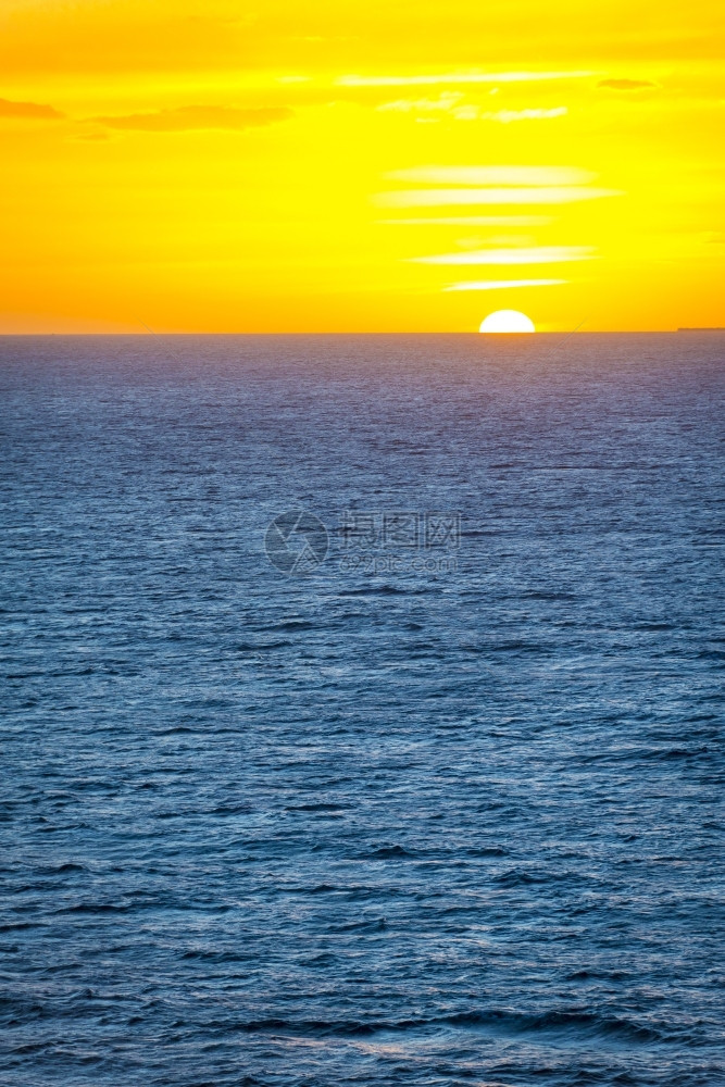 温和的多云阳光海面上日落平线直和温柔的海洋波浪图片