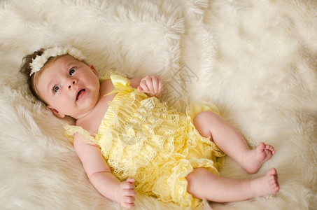 蕾丝可爱的两个月大女婴躺在粉红色毯子背上好的柔软图片