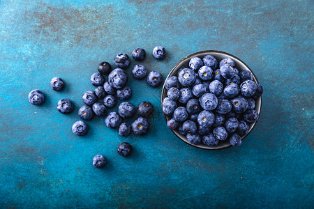 木头在碗里的美丽背景上充满果汁和新鲜的蓝莓夏天植物图片