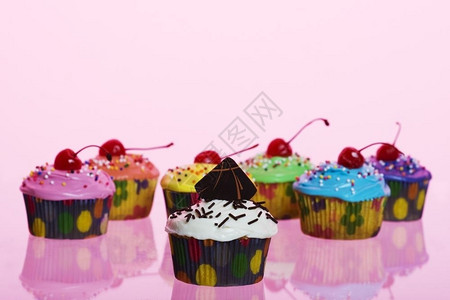 黄色的种类生日各花哨的纸杯蛋糕用粉红胶卷拍摄背景图片